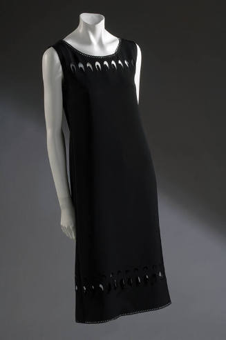 Black sleeveless pullover shift dress with bands of oval and circle cut-out slices at upper bod…