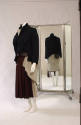 Navy cutaway jacket with attached beige vest lining and dark red skirt