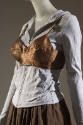 Brown bra styled over gray long sleeve zip up sweater, brown wrap skirt 