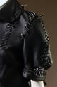 Elbow length sleeve detail of black leather jacket pieced with large whipstitch and saddle stic…