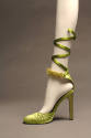 Green high heel with serpentine strap along calf and fur trim