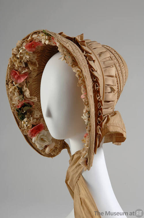 Beige bonnet trimmed with lace and cloth flowers inside brim, neck tie