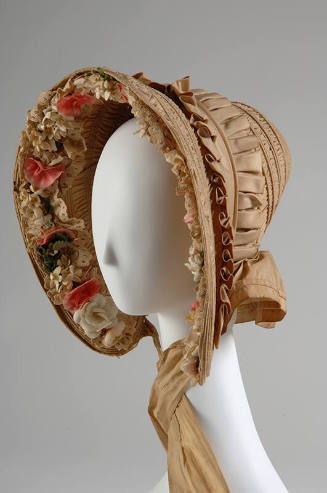 Beige bonnet trimmed with lace and cloth flowers inside brim, neck tie