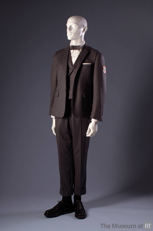 Grey wool suit with long sleeve jacket with patch, vest, and short cuffed pants and bow tie