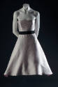 Pale pink strapless dress with full bell to-the-knee skirt and black ribbon belt