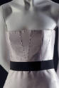 Detail of pale pink strapless bodice with black ribbon belt 