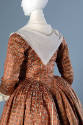 Back detail of brown silk dress with blue flowers in grid pattern and off-white neckerchief
