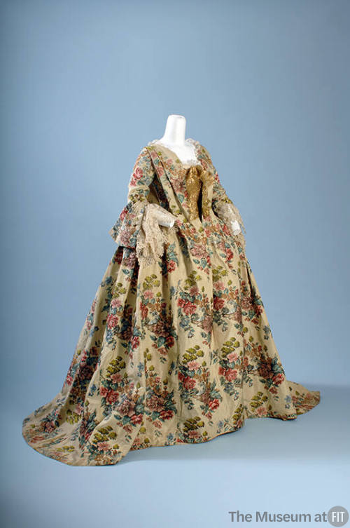 Floral pattern brocaded silk floor length gown with 3/4 sleeves with lace trim, gold bow at low…