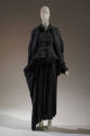 Black silk long sleeve jacket with large lapels, matching cage corset and floor length pleated …