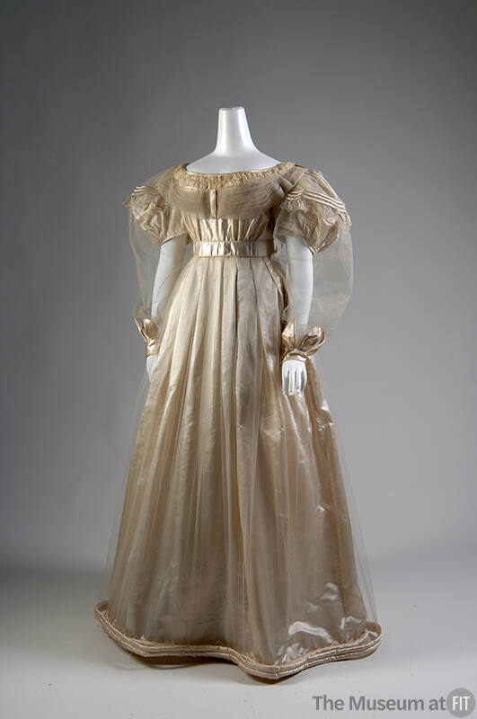 Off-white satin floor length dress with net overlay, puff sleeves with sheer long net over slee…