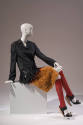 Black long sleeve coat with black plastic straw fringe and orange faux fur hem, red knee socks …