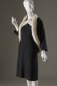 Black knee length dress and matching short jacket, both with white fur trim 