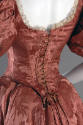 Detail view of lace-up back of pink dress bodice with lace trim 