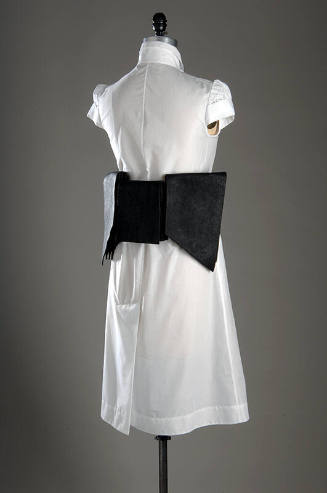Back view of white cap sleeve to-the-knee dress with wide black leather layered belt