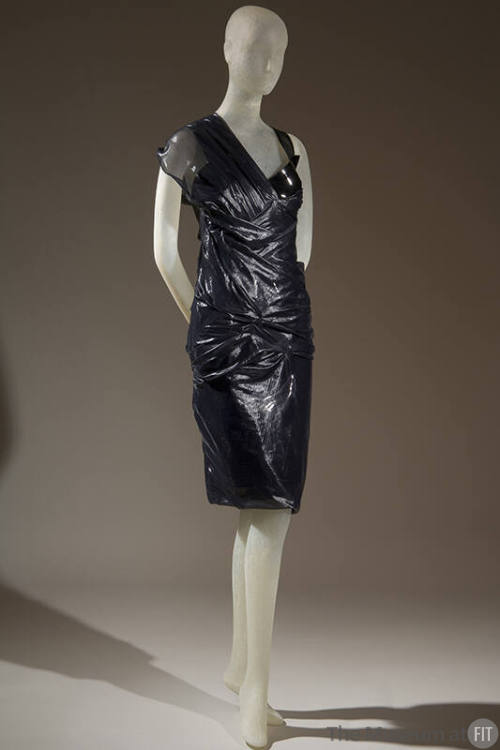 Black patent leather textured knee length dress with one sheer cap sleeve and one shoulder stra…