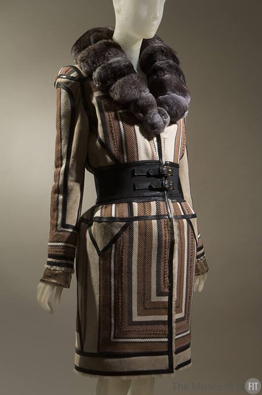 Coat in geometric stripes of brown, tan, off-white and black with wide black double buckle clos…