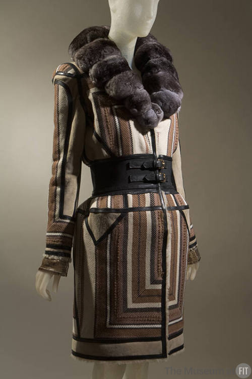 Coat in geometric stripes of brown, tan, off-white and black with wide black double buckle clos…