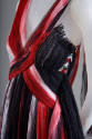Detail view of red, black and white dress showing criss-cross bodice that creates deep V-neckli…