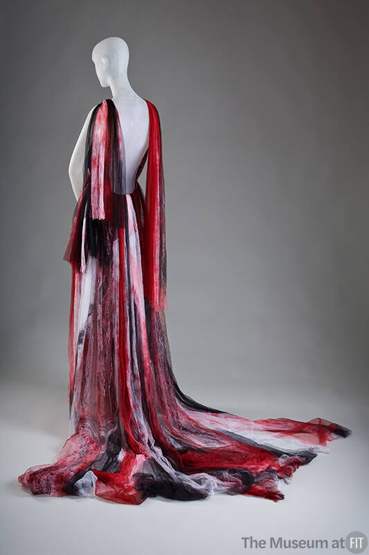 Back view of red, black and white sleeveless floor length evening gown with tie-dye effect, str…