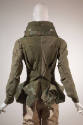 Back view of army green jacket showing oversize stand collar, sculpted peplum and decorative ha…