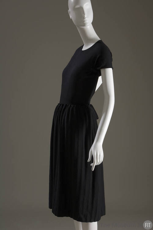 Side view of black short sleeve dress with vertical self fabric stripes on just below knee leng…