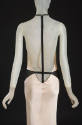 Back view of beige silk dress with open back and single black ribbon extending from neck tie do…