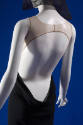 Back view of black sleeveless jumpsuit showing beige upper bodice and open back with deep scoop…
