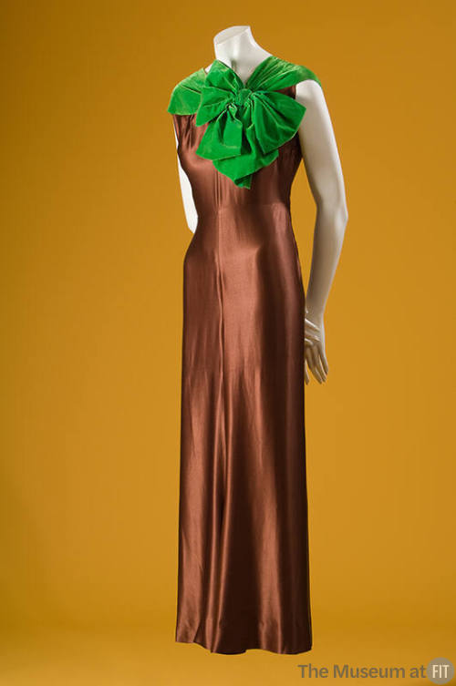 Brown silk sleeveless below ankle evening gown with bright green velvet neckline and oversize b…