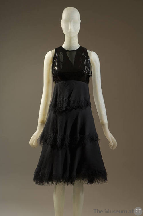 Black sleeveless dress with patent leather bodice and tired knee length skirt with fringed hems