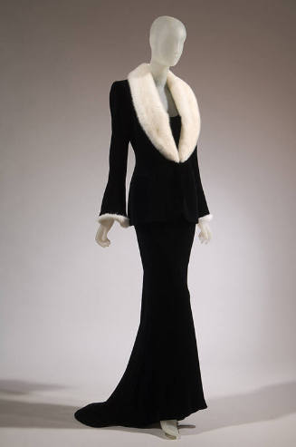 Black velvet evening ensemble of fitted jacket with bell sleeves and white fur deep shawl colla…