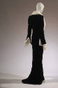Back view of black velvet evening ensemble showing white fur trim in split sleeve cuffs and tra…