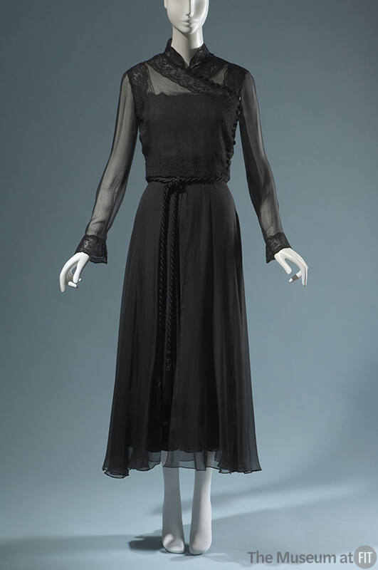Black evening ensemble of sheer long sleeve cross over top and floor length skirt with braided …