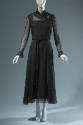 Black evening ensemble of sheer long sleeve cross over top and floor length skirt with braided …