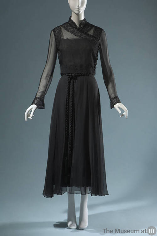 Black evening ensemble of sheer long sleeve cross over top and floor length skirt with braided …