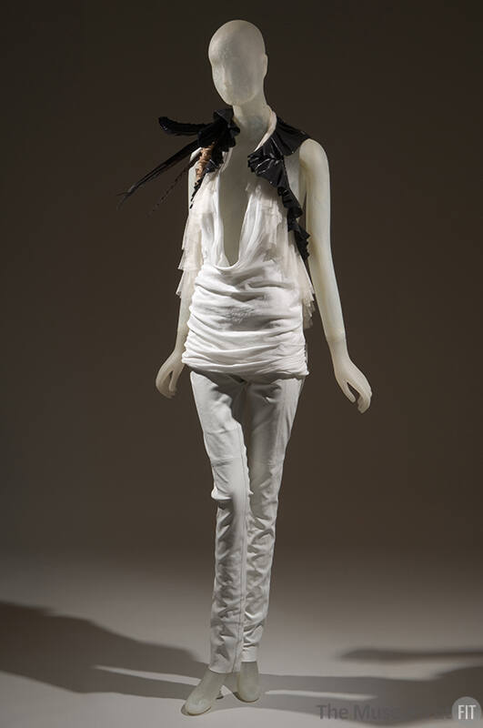 Ensemble of white halter top with plunging neckline trimmed with white and black ruffles, black…