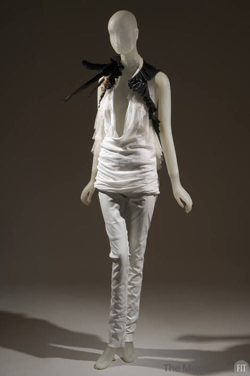 Ensemble of white halter top with plunging neckline trimmed with white and black ruffles, black…