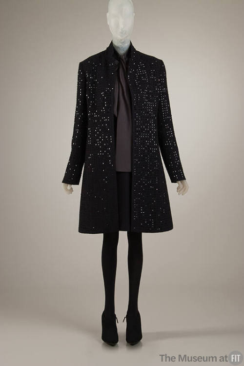 Ensemble of black coat embellished with square black paillettes, dark grey blouse, black above …