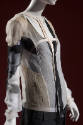 ¾ view of sheer beige, black and white irregular patchwork jacket with blank pants