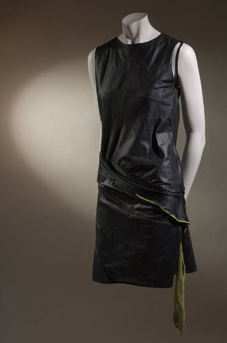 Black sleeveless mini dress with diagonal seaming and attached chartreuse panel at dropped wais…