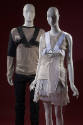 Man’s brown and black sweater, black chest harness and black pants on left with women’s grey an…