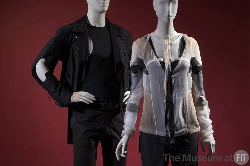 Man’s black motorcycle style jacket, tank top and pants on left with women’s sheer beige, black…