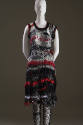 Black, red and white sleeveless knee length dress in loose net-like knit with matching black ti…