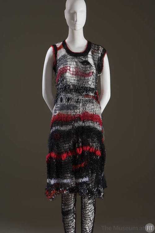 Black, red and white sleeveless knee length dress in loose net-like knit with matching black ti…