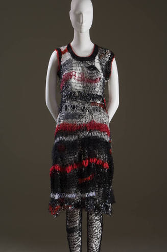 Black, red and white sleeveless knee length dress in loose net-like knit with matching black ti…