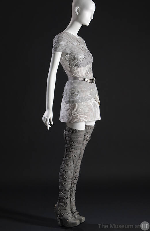 ¾ view of grey and white mini dress of piecework marbled leather and cotton tulle with single l…