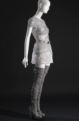 ¾ view of grey and white mini dress of piecework marbled leather and cotton tulle with single l…