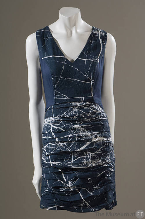 Sleeveless blue satin v-neck mini dress with allover white splatter print and pleated skirt