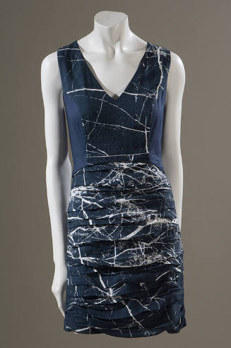 Sleeveless blue satin v-neck mini dress with allover white splatter print and pleated skirt