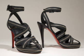 Black high heel sandals with multiple criss-cross zipper straps and ankle buckle straps 