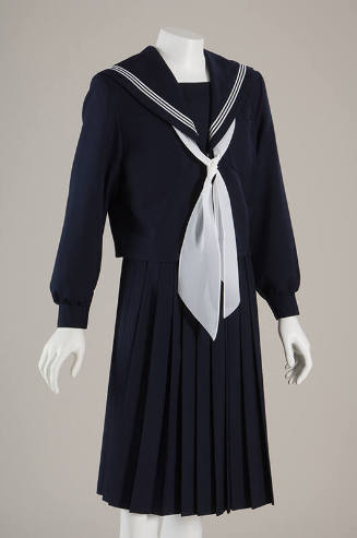 Dark blue school uniform top with sailor neck with white bow tie, matching pleated to-the-knee …